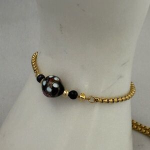 Handmade gold tone bolo style bracelet with vintage black glass bead